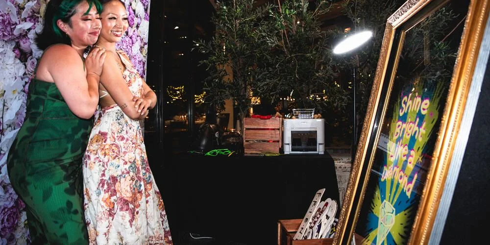 Two people pose and smile for a photo with the Matt Jefferies Entertainment Mirror Booth Melbourne