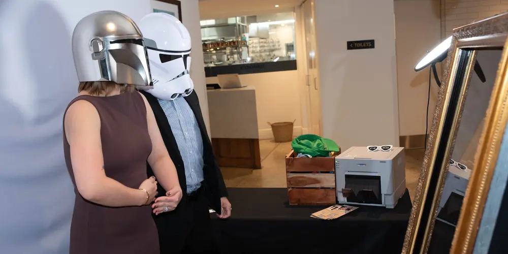 Guests wearing fun Star Wars helmets pose for a picture with the Matt Jefferies Entertainment Mirror Booth Melbourne